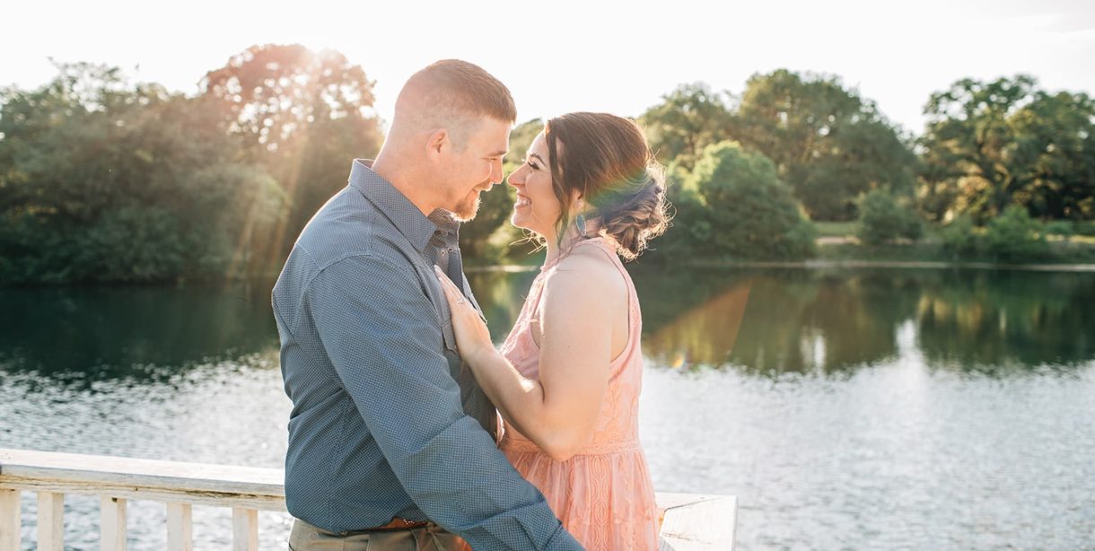 couple standing on a dock by the lake for a romantic photo at BlissWood B&B